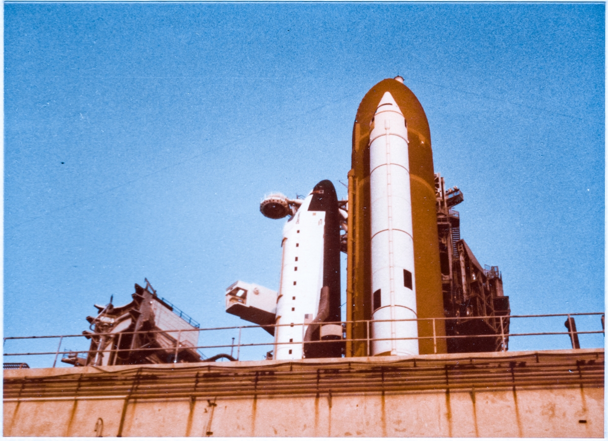 August 10, 1984, Space Shuttle Discovery, initial rollout to Launch Complex 39-A, Kennedy Space Center, Florida, prior to its first launch, viewed from the access road leading to the high-pressure gas facility on the east side of the pad.